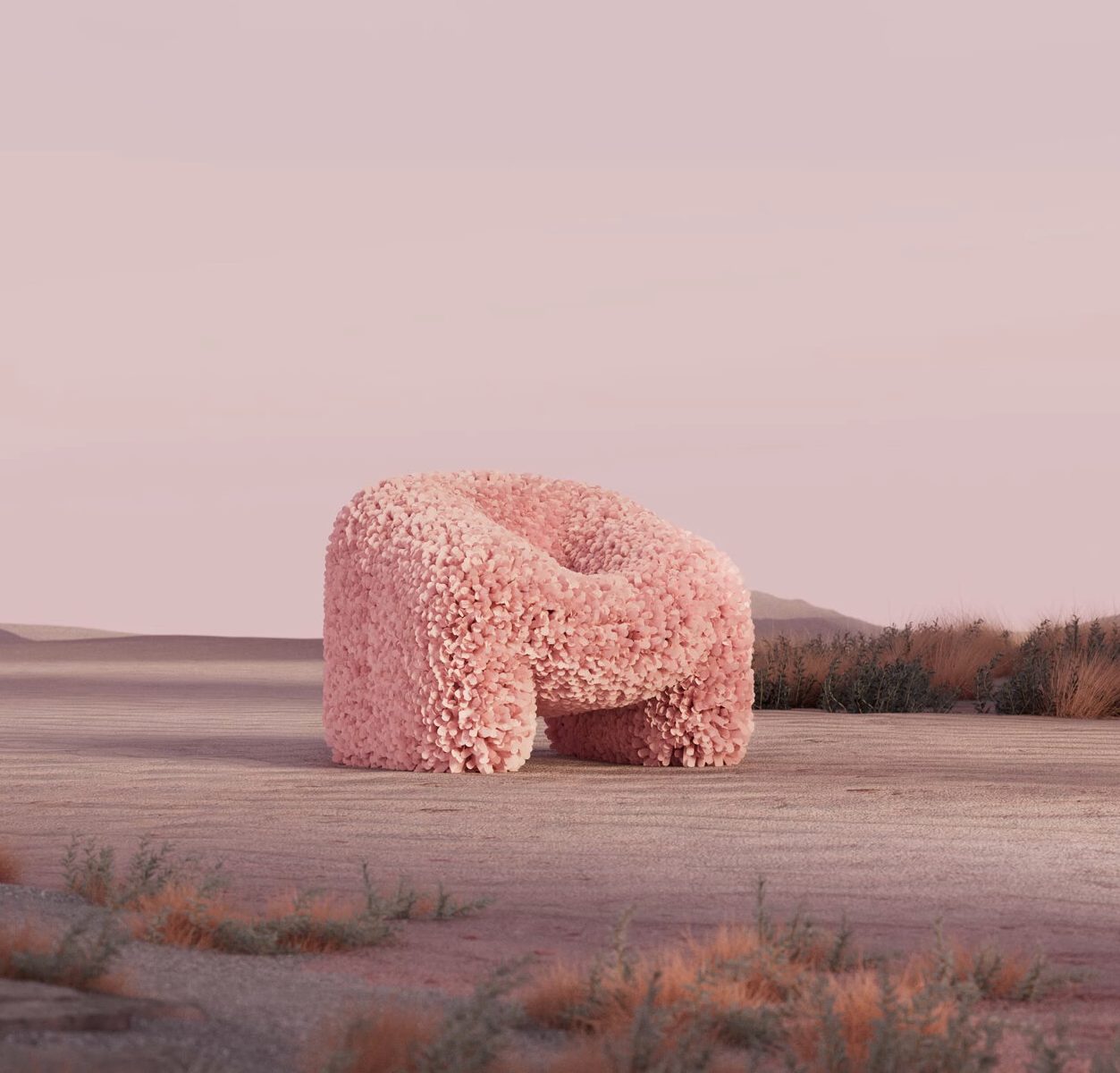 Pink textured armchair sculpture in surreal desert landscape, part of the New FuTure exhibition in Barcelona.